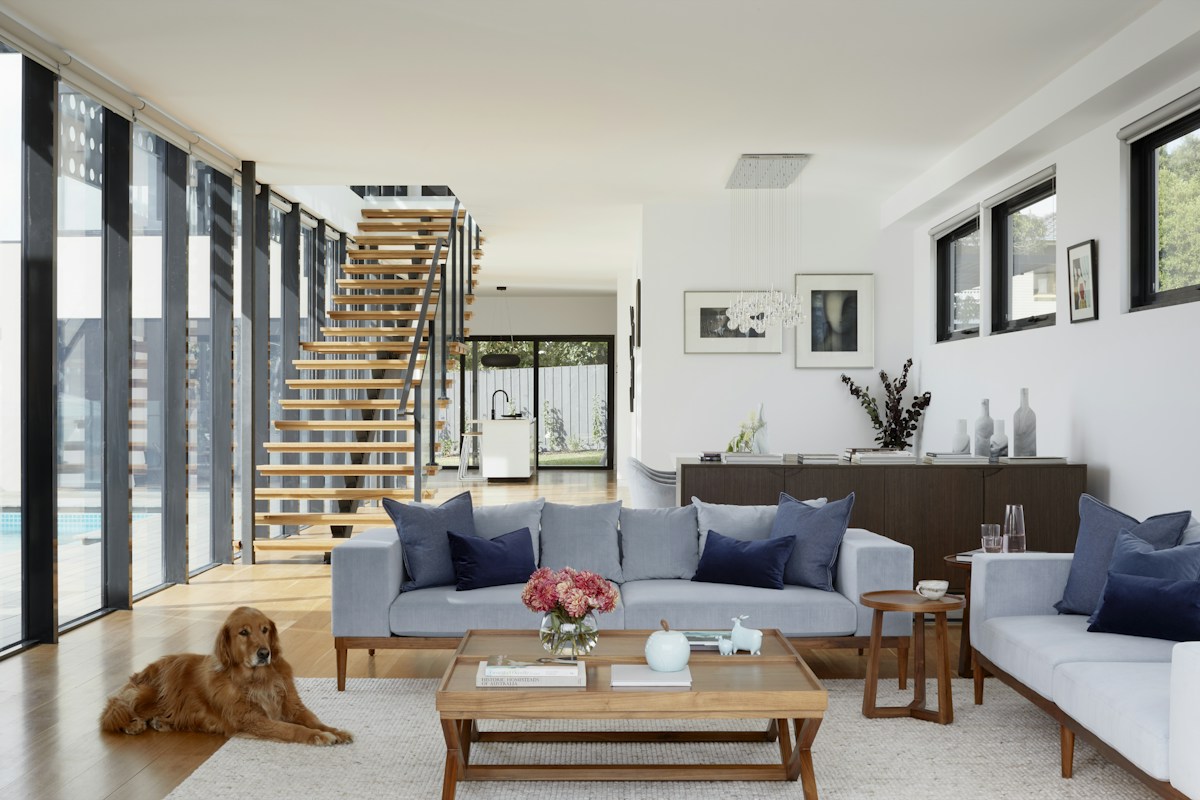 Light-filled living room with natural wood, generous windows and comfortable seating